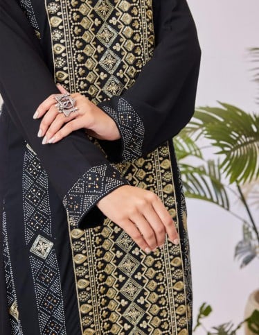 Black jalabiya with geometric embroidery.
